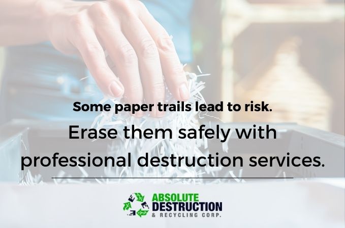 Hand feeding paper into a shredder to eliminate sensitive documents safely, promoting secure services by Absolute Destruction