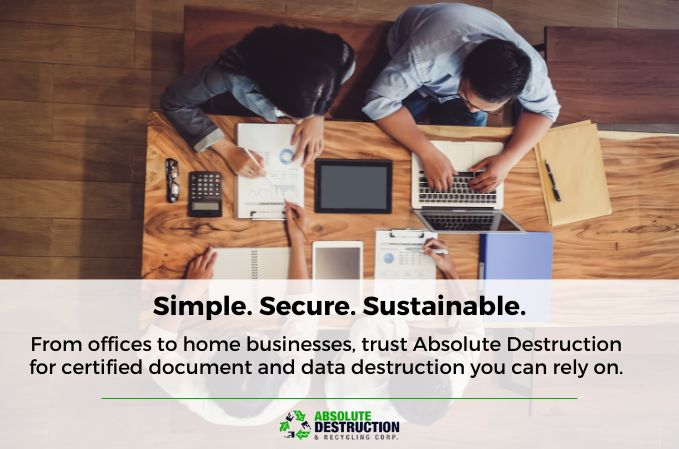 Team working with laptops and documents at a desk, illustrating Absolute Destruction's simple, secure, and sustainable approach to certified data and document destruction for businesses.